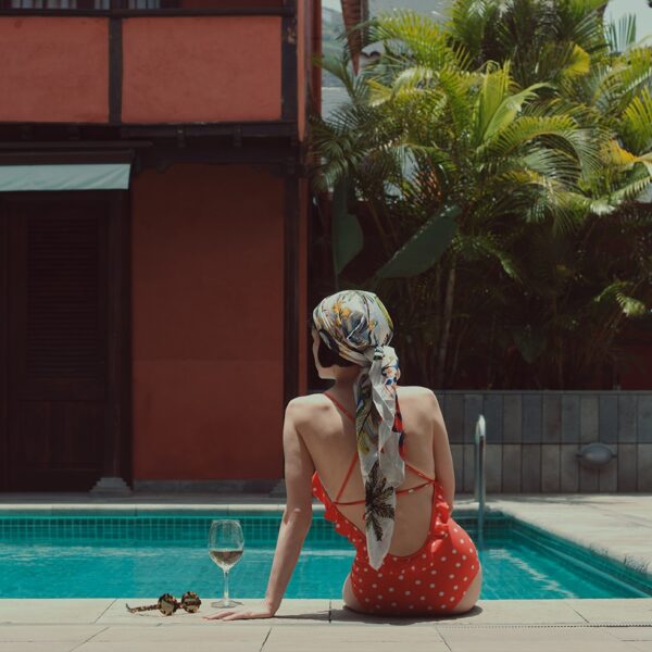 Huésped sentada en el borde de la piscina en el Hotel San Roque, Garachico, Tenerife Norte