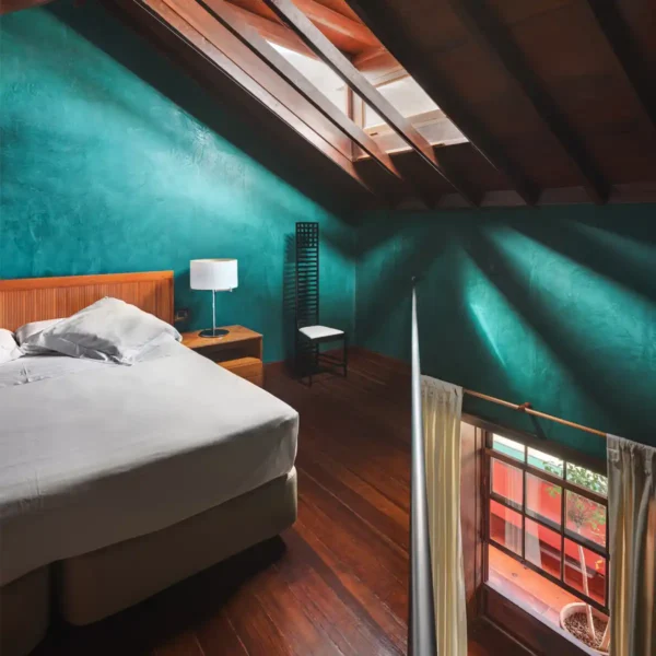 Habitación dúplex con techo abuhardillado, luz natural y vistas interiores en el Hotel San Roque
